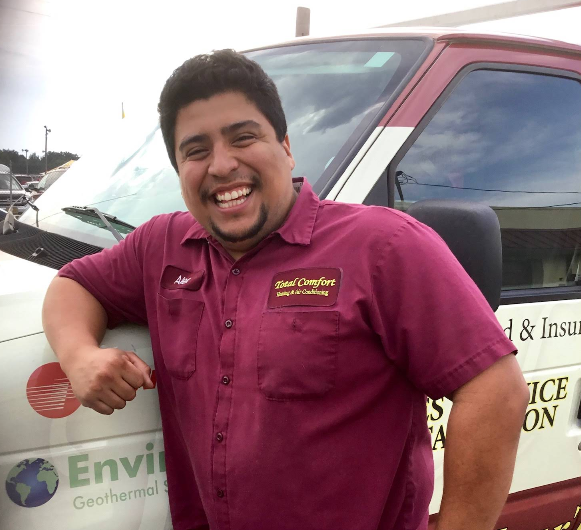 A Total Comfort technician smiling in front of their branded HVAC van