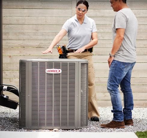 Total Comfort HVAC tech installing a new AC unit while explaining the AC system to the owner