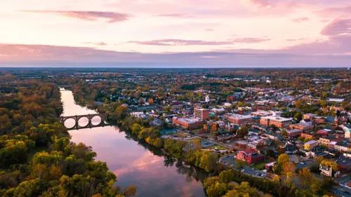An aerial view of Fredericksburg, Virginia, and the surrounding areas with the Rappahannock River and the downtown area visible at sunrise.
